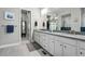 Bathroom featuring dual vanities and a stylish tiled shower at 6469 Barnstead Dr, Castle Pines, CO 80108