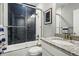 Stylish bathroom with a combined shower and tub featuring navy blue tile, along with a granite sink at 6469 Barnstead Dr, Castle Pines, CO 80108
