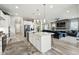 Open kitchen flowing into the living area, featuring an island with seating and modern appliances at 6469 Barnstead Dr, Castle Pines, CO 80108
