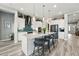 Elegant kitchen featuring a large island with seating, ample cabinet space, and modern lighting at 6469 Barnstead Dr, Castle Pines, CO 80108