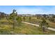 Well-maintained community walking path winding through lush grassy areas and trees at 6469 Barnstead Dr, Castle Pines, CO 80108