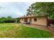 The serene backyard features lush green grass, patio seating, and a charming brick home, perfect for outdoor enjoyment at 1285 Elder St, Denver, CO 80221