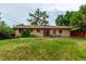 The backyard offers a well-maintained lawn, patio seating, and brick home exterior, creating an inviting outdoor space at 1285 Elder St, Denver, CO 80221