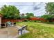 Spacious backyard featuring a well-maintained lawn, garden, patio with outdoor seating, and a wood fence at 1285 Elder St, Denver, CO 80221