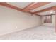 Unfinished basement featuring neutral carpet, exposed beams, and a window for ample natural light at 1285 Elder St, Denver, CO 80221