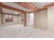 Finished basement features neutral carpet, exposed beams, window, mirrored closet, and a door for access at 1285 Elder St, Denver, CO 80221