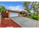 The driveway leads to a spacious two-car garage, surrounded by red mulch and mature landscaping at 1285 Elder St, Denver, CO 80221