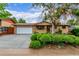 Charming brick home with a well-maintained front yard, mature tree, and a large driveway at 1285 Elder St, Denver, CO 80221