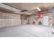 Unfinished garage features concrete flooring and exposed beams, complete with a window and door for convenience at 1285 Elder St, Denver, CO 80221