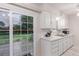 Bright, efficient kitchen featuring white cabinetry, stainless steel sink, and a sliding glass door to the backyard at 1285 Elder St, Denver, CO 80221