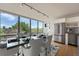 Modern dining room featuring stainless steel appliances, hardwood floors, and expansive windows with lush views at 3100 E Cherry Creek South Dr # 404, Denver, CO 80209