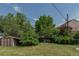 Large green backyard with mature trees and privacy landscaping and shed at 1540 S Knox Ct, Denver, CO 80219