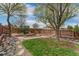 Landscaped backyard with patio area, stone pathway, and grass, creating a peaceful outdoor retreat at 10475 E Abilene St, Commerce City, CO 80022