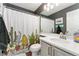 Stylish bathroom with a cactus-themed shower curtain, ample lighting, and a clean, modern design at 10475 E Abilene St, Commerce City, CO 80022