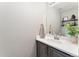A clean half-bathroom featuring a modern vanity, towel, and stylish decor for a functional space at 10475 E Abilene St, Commerce City, CO 80022