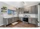 Bright kitchen with stainless steel appliances, subway tile backsplash, and hardwood floors at 10475 E Abilene St, Commerce City, CO 80022