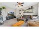 Comfortable living room featuring a large sectional sofa, floating shelves, and a modern ceiling fan at 10475 E Abilene St, Commerce City, CO 80022