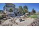 Beautiful backyard featuring stone accents, multiple patio areas, mature landscaping, and scenic views at 14955 W 58Th Pl, Golden, CO 80403