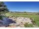 Backyard featuring tiered stone landscaping, a fire pit, and views of open land with distant mountains at 14955 W 58Th Pl, Golden, CO 80403