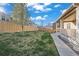 Spacious backyard features lush green grass, mature tree, and a wood fence for privacy and enjoyment at 14275 Grape St, Thornton, CO 80602
