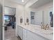 Bathroom featuring double sink vanity with marble countertop and a full mirror wall at 14275 Grape St, Thornton, CO 80602