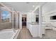 Ensuite bathroom featuring double sinks, a glass shower, and a soaking tub at 14275 Grape St, Thornton, CO 80602