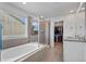 Bright bathroom with walk-in shower, and a soaking tub near the windows at 14275 Grape St, Thornton, CO 80602