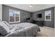 Comfortable bedroom features neutral carpet, two windows and black-painted walls at 14275 Grape St, Thornton, CO 80602