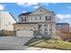 Charming two-story home with well-maintained lawn, a two car garage and covered porch on a sunny day at 14275 Grape St, Thornton, CO 80602