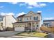 Charming two-story home with well-maintained lawn, a two car garage and covered porch on a sunny day at 14275 Grape St, Thornton, CO 80602