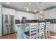 Bright kitchen with stainless steel appliances, island with seating, and modern pendant lighting at 14275 Grape St, Thornton, CO 80602