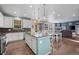 Open-concept kitchen featuring an island with seating, stainless appliances, and seamless connection to living areas at 14275 Grape St, Thornton, CO 80602