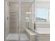 Clean and modern bathroom with a glass-enclosed shower and a relaxing soaking tub at 6591 N Ceylon St, Denver, CO 80249