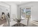 Bright dining area with glass table and modern chairs, adjacent to sliding glass door and study at 6591 N Ceylon St, Denver, CO 80249