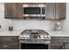 Close up of gourmet range, designer backsplash, stainless steel appliances, and granite countertops in kitchen at 6591 N Ceylon St, Denver, CO 80249