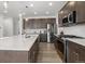 Modern kitchen with a large island, stainless steel appliances, and a tiled backsplash at 6591 N Ceylon St, Denver, CO 80249