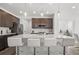 Modern kitchen featuring a large island with seating, stainless steel appliances, and stylish pendant lighting at 6591 N Ceylon St, Denver, CO 80249