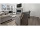Bright living room features large windows, plush seating, and a modern fireplace with mounted TV at 6591 N Ceylon St, Denver, CO 80249