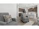 Open-concept living space connects to a modern kitchen, featuring sleek furniture and neutral decor at 6591 N Ceylon St, Denver, CO 80249