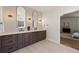 Elegant bathroom with double vanity, oval mirrors, and warm lighting creating a luxurious space at 5302 Pinehurst Dr, Boulder, CO 80301