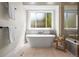 Modern bathroom with a freestanding tub, sleek fixtures, and a window offering a view at 5302 Pinehurst Dr, Boulder, CO 80301