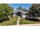 Charming one-story home featuring a landscaped front yard and classic architectural details, with lush trees surrounding the property at 5302 Pinehurst Dr, Boulder, CO 80301