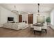 Spacious living room and dining area with hardwood floors, a modern fireplace, stylish lighting, and ample natural light at 5302 Pinehurst Dr, Boulder, CO 80301