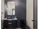 Modern powder room featuring a stylish black vanity with marble countertop, striking black tile, and contemporary lighting at 5302 Pinehurst Dr, Boulder, CO 80301