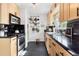 Modern kitchen featuring stainless steel appliances, stylish cabinets, and black countertops at 2734 King St, Denver, CO 80211