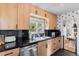 Updated kitchen with black countertops, wood cabinets, and stainless steel dishwasher at 2734 King St, Denver, CO 80211