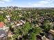 Picturesque aerial view showcasing a vibrant neighborhood with lush greenery and a stunning city skyline backdrop at 2734 King St, Denver, CO 80211