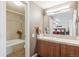 Well-lit bathroom with a large mirror, wood cabinets, tile flooring, and a separate tub and shower at 8170 E Phillips Cir, Centennial, CO 80112