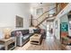 Stylish living room with wood floors, a comfortable sectional sofa, and modern staircase leading to a second story at 8170 E Phillips Cir, Centennial, CO 80112
