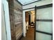 Hallway with wood accent wall leading to bathroom with sliding barn door at 614 Rose St, Georgetown, CO 80444